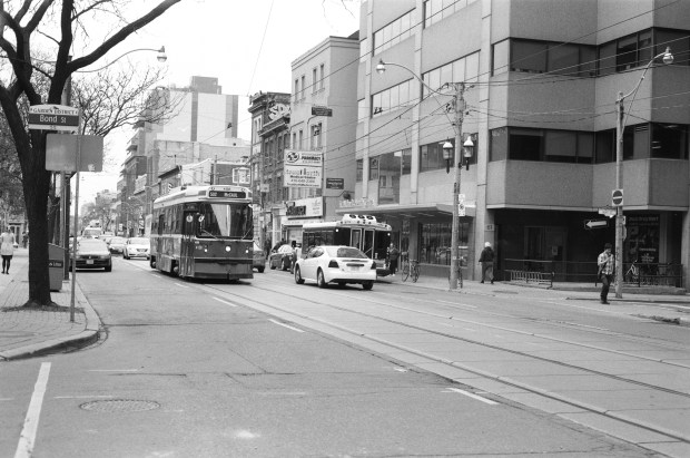 One of many TTC Streetcars rolling on the rails along Queen Street.